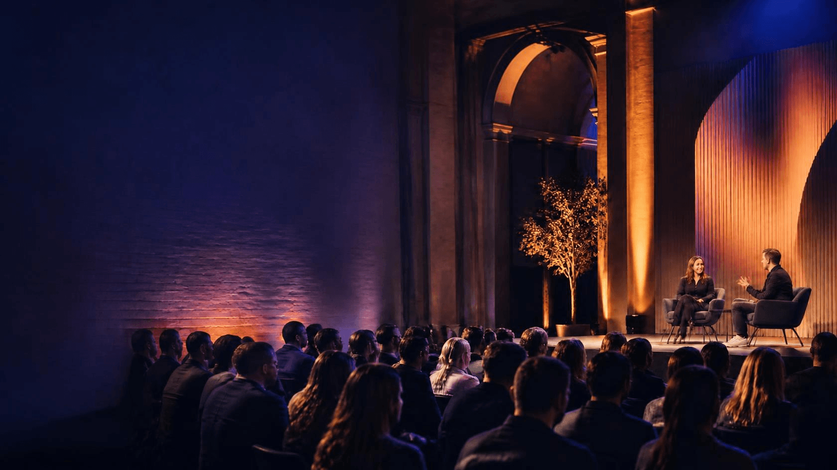 A fireside-chat style discussion on stage at a health and care industry event, in front of a seated audience